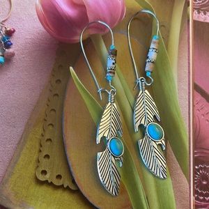 Silver toned feather earrings, with a faux turquoise gem and bead work